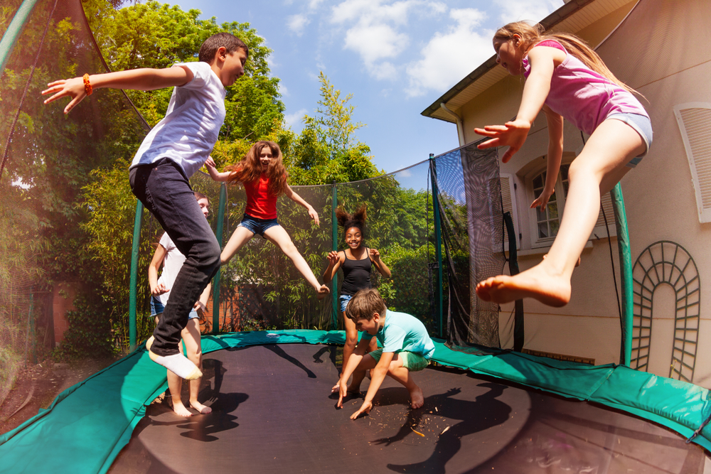 Happy,Friends,Jumping,On,The,Trampoline,In,Summer