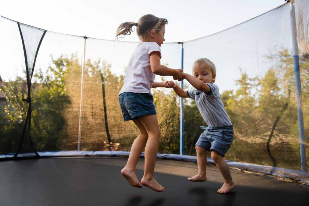 Elder,Sister,Holding,Hands,Of,Her,Brother,And,Jumping