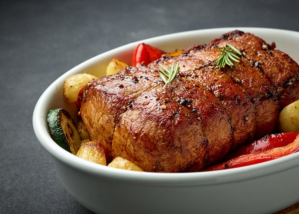Bowl,Of,Whole,Roast,Pork,And,Vegetables,On,Dark,Grey