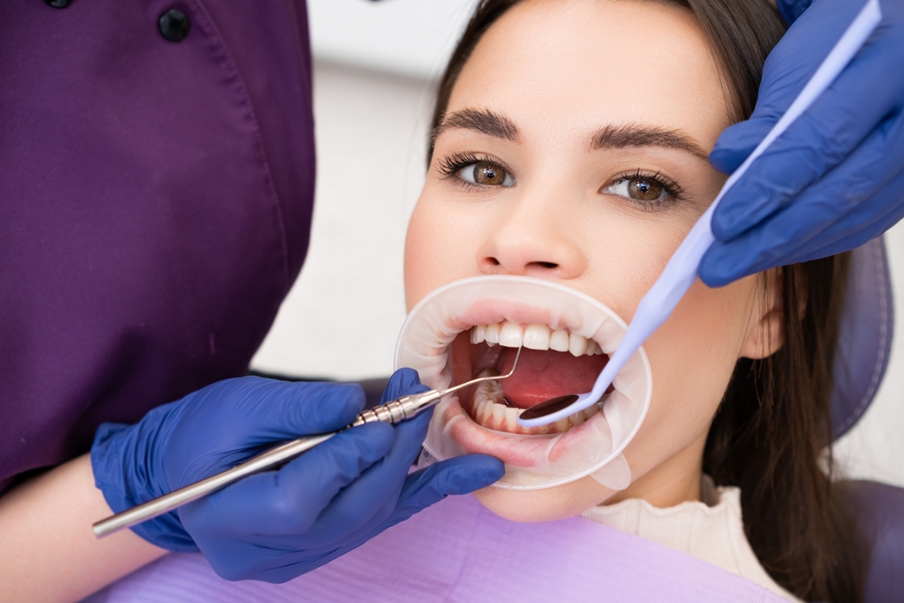 Woman,Patient,Undergoes,Dental,Treatment,In,Clinic.,Female,Dentist,In