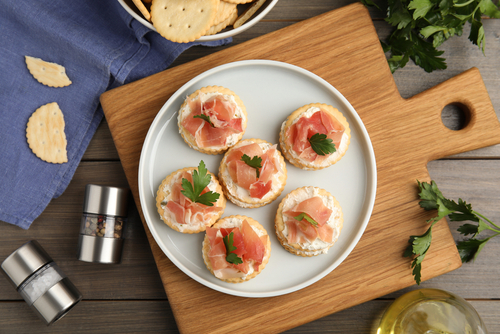 Delicious,Crackers,With,Cream,Cheese,,Prosciutto,And,Parsley,On,Wooden