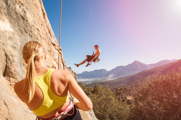 Couple,Of,Rock,Climbers,-,Woman,Holding,Man,With,Belay