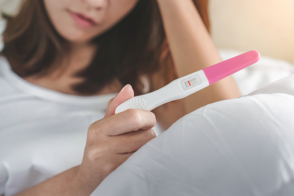 Unhappy,Young,Asian,Woman,Holding,Pregnancy,Test,Showing,A,Negative
